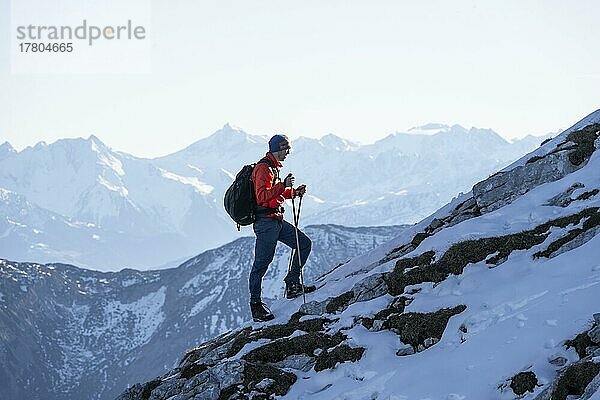 Bergsteiger am felsigen Gipfelgrat mit erstem Schnee im Herbst  Wanderweg zum Guffert  hinten Bergpanorama  Brandenberger Alpen  Tirol  Österreich  Europa