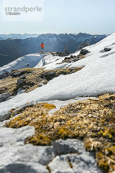 Bergsteiger neben einem Steinmännchen  vor verschneiten Bergen des Rofan  Wanderweg zum Guffert mit erstem Schnee  im Herbst  Brandenberger Alpen  Tirol  Österreich  Europa