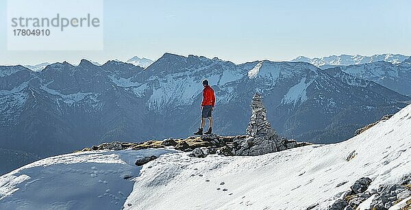 Bergsteiger neben einem Steinmännchen  vor verschneiten Bergen des Rofan  Wanderweg zum Guffert mit erstem Schnee  im Herbst  Brandenberger Alpen  Tirol  Österreich  Europa