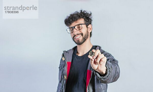 Lächelnder Mann hält Bitcoin-Münze  Hübscher Mann zeigt Bitcoin-Münze  Person hält Bitcoin-Münze isoliert