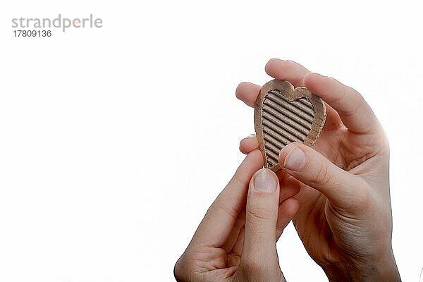 Isolierte Herzform Loch durch Karton in der Hand