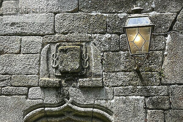 Wappen und Straßenlaterne an der Fassade eines alten Steinhaus  Locronan  als eines der schönsten Dörfer Frankreichs ausgezeichnet  Departement Finistere Penn-ar-Bed  Region Bretagne Breizh  Frankreich  Europa