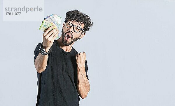 Glücklicher gutaussehender Mann mit Geld in der Hand  erstaunte Menschen mit Geldscheinen in der Hand  aufgeregte Person mit Geld in der Hand isoliert