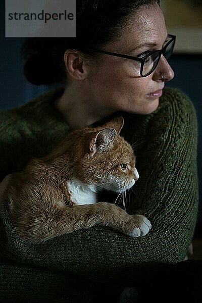 Porträt einer Frau mit Katze im Arm  Innenaufnahme
