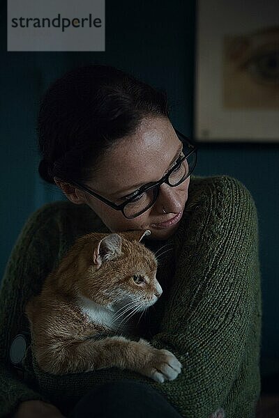 Porträt einer Frau mit Katze im Arm  Innenaufnahme