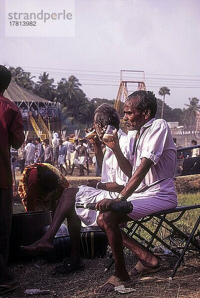 Menschen beim Teetrinken in der Nähe einer Ausstellung während des Pooram Festes in Thrissur oder Trichur  Kerala  Indien  Asien