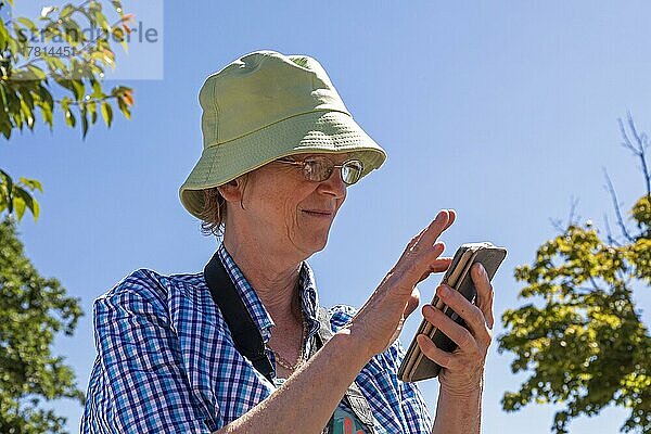 Ältere Frau tippt auf Smartphone  Wustrow  Mecklenburg-Vorpommern  Deutschland  Europa