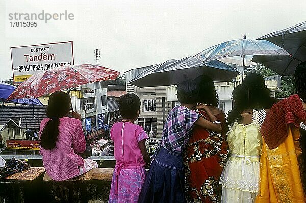 Mädchen mit Regenschirm bewundern die Atham Festprozession in Tripunithura bei Ernakulam  Kerala  Indien. Monsun