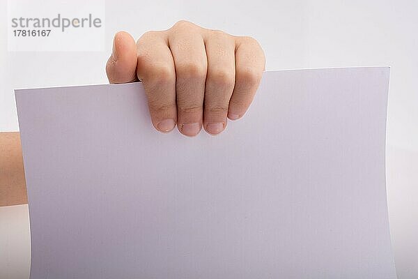 Hand hält ein weißes Blatt Papier auf weißem Hintergrund