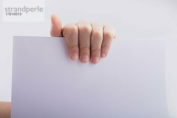 Hand hält ein weißes Blatt Papier auf weißem Hintergrund