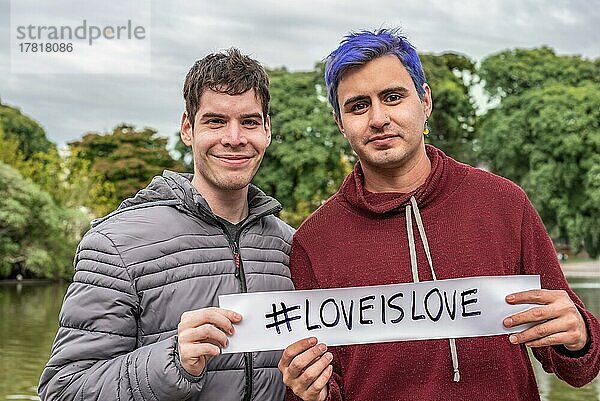Ein homosexuelles Paar zeigt ein Liebe ist Liebe Zeichen. LGBT Konzept