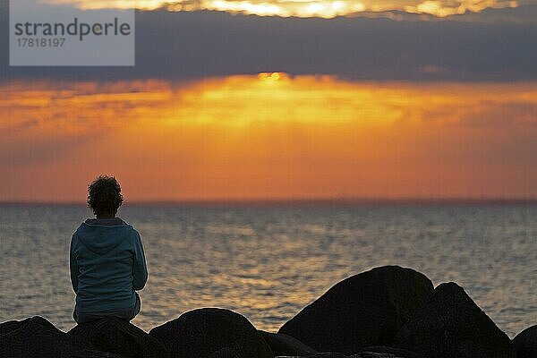 Frau sitzt auf Steinen  Sonnenuntergang  Steinbeck  Klütz  Mecklenburg-Vorpommern  Deutschland  Europa