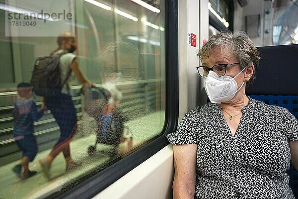 ältere Frau mit Mundschutzmaske  sitzt in S-Bahn  auf dem Bahnsteig Reisende  Sommerwelle  Corona-Krise  Stuttgart  Baden-Württemberg  Deutschland  Europa