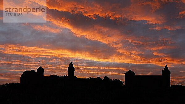 Feuerroter Abendhimmel nach Sonnenuntergang mit Skyline  Silhouette von links Kaiserburg mit Heidenturm und Sinwellturm  rechts ehemalige Kaiserstallung mit Fünfeckturm und Luginslandturm  heute DJH Jugendherberge Nürnberg  Altstadt  Nürnberg  Mittelfanken  Franken  Bayern  Deutschland  Europa