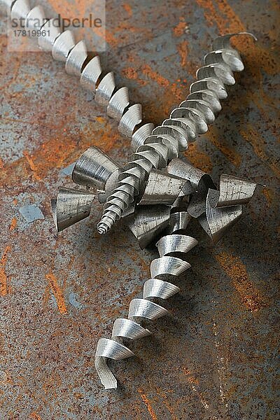 Spiralförmige Metallspäne liegen auf einer rostigen Metallplatte  Studioaufnahme