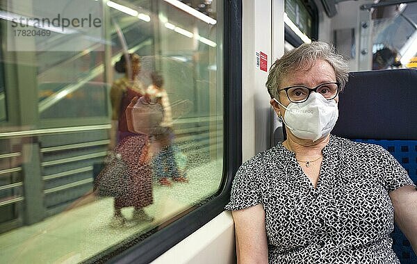 ältere Frau mit Mundschutzmaske  sitzt in S-Bahn  auf dem Bahnsteig Reisende  Sommerwelle  Corona-Krise  Stuttgart  Baden-Württemberg  Deutschland  Europa