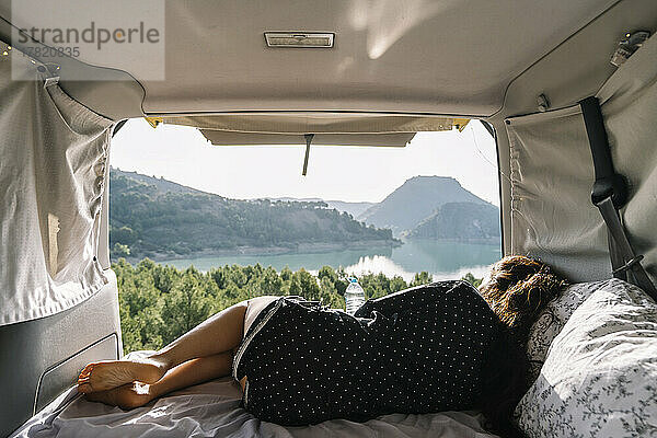 Frau entspannt sich im Urlaub im Van