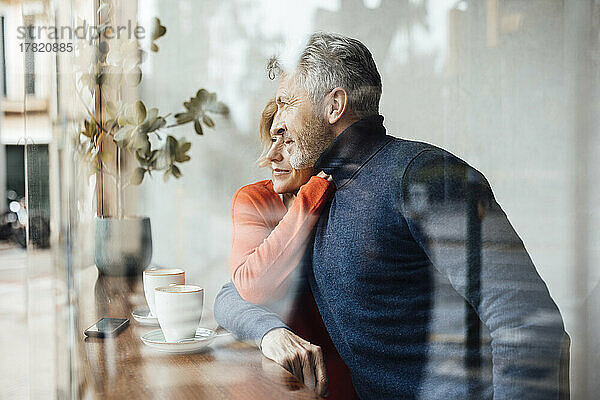 Mann und Frau im Café durch Glas gesehen