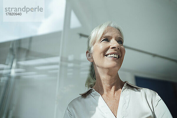 Happy businesswoman with white hair in office