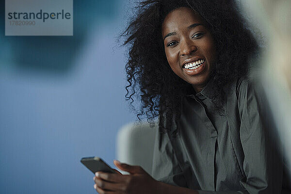 Smiling woman holding smart phone