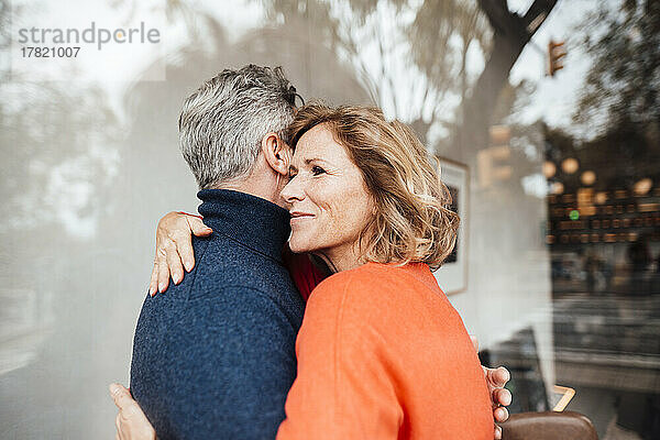 Smiling woman embracing man in cafe