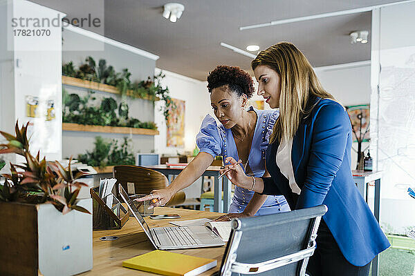 Geschäftsfrauen diskutieren am Laptop im Büro