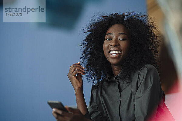 Happy young woman holding smart phone