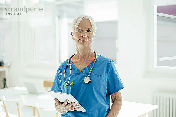 Smiling female doctor holding tablet PC