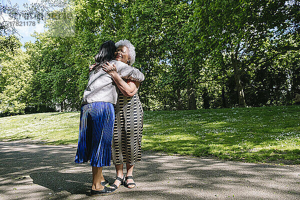 Mutter umarmt Tochter im Park