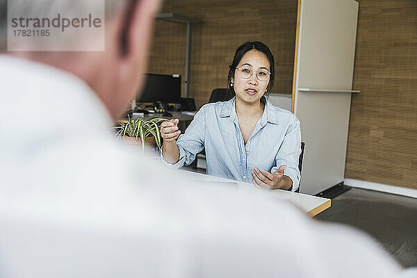 Businesswoman discussing work with colleague at work place