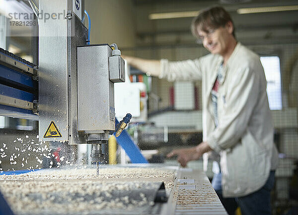 Reifer Mann mit CNC-Maschine  der in der Fabrik arbeitet