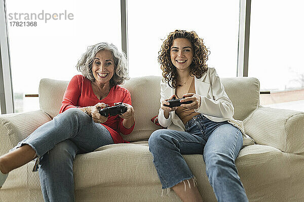 Glückliche Frau mit Freundin  die Videospiele spielt