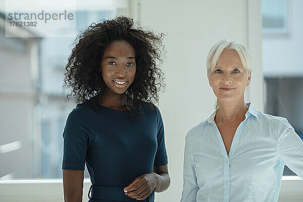 Smiling senior businesswoman with colleague in office