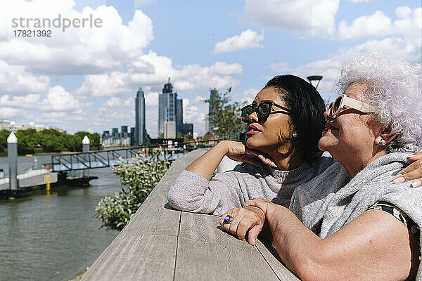 Mutter und Tochter stehen an einem sonnigen Tag an der Battersea Bridge