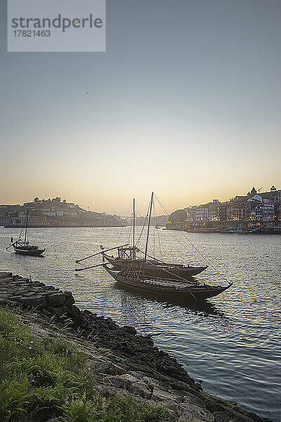 Portugal  Distrikt Porto  Vila Nova de Gaia  Segelboote im Fluss Douro mit Stadt und untergehender Sonne im Hintergrund