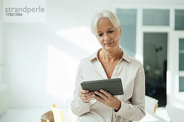 Ältere Geschäftsfrau nutzt Tablet-PC im Büro