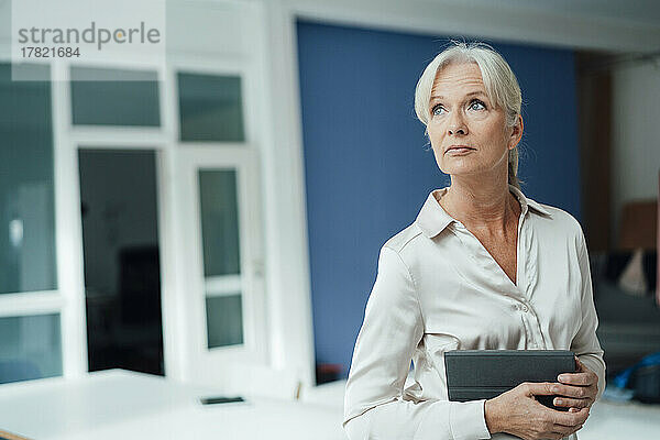 Senior businesswoman holding tablet PC in office