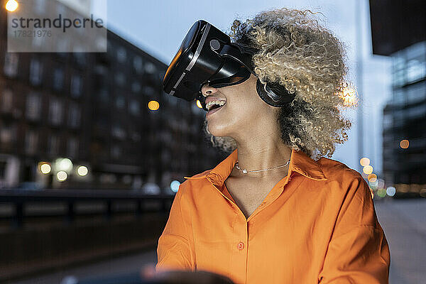 Glückliche Frau  die nachts ein Virtual-Reality-Headset trägt