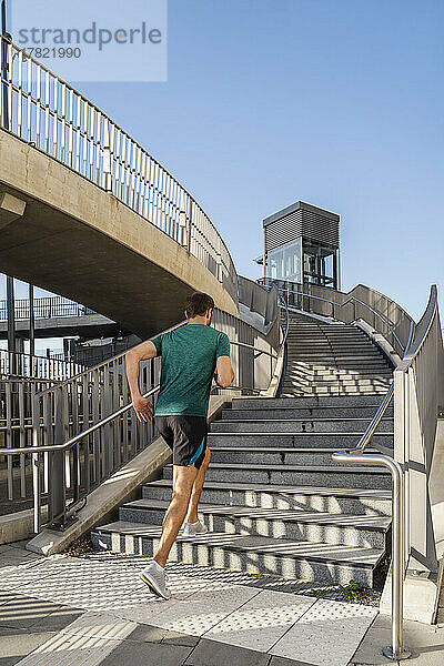 Mann in Sportkleidung joggt auf Treppe