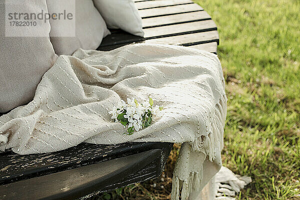 White flower on blanket at bench in garden