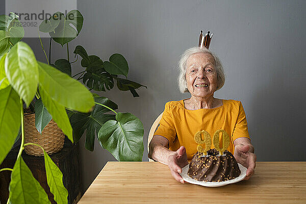 Glückliche ältere Frau  die zu Hause Geburtstag mit Kuchen feiert