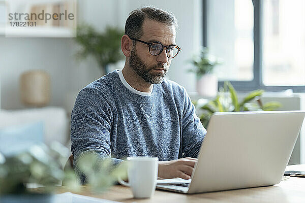 Reifer Freiberufler  der von zu Hause aus mit einem Laptop arbeitet