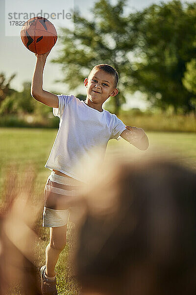 Junge wirft Schwester an sonnigem Tag Rugbyball zu