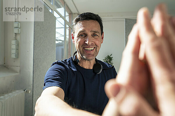 Lächelnder Geschäftsmann gibt einem Kollegen im Büro ein High-Five