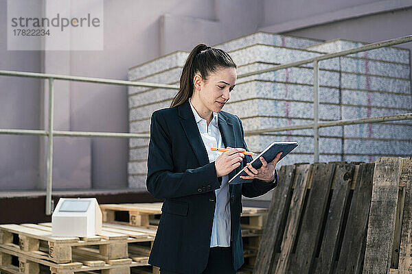 Geschäftsfrau arbeitet in der Fabrik am Tablet-PC