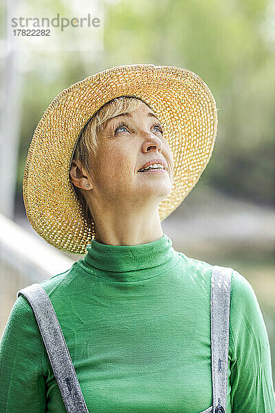 Mature woman wearing hat looking up