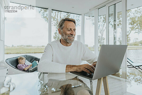 Smiling freelancer working on laptop at home