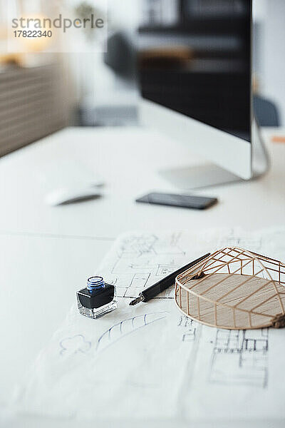 Architekturmodell und Bauplan auf dem Schreibtisch im Büro