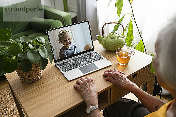 Ältere Frau spricht per Videoanruf mit Enkelin über Laptop