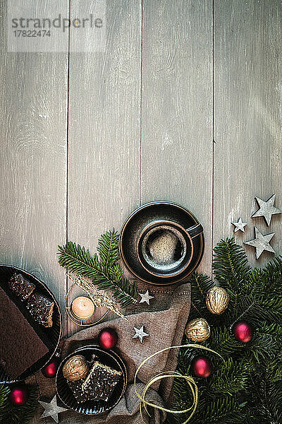Studioaufnahme einer Tasse Kaffee  Zweigen  Walnüssen  Weihnachtsschmuck und Lebkuchen